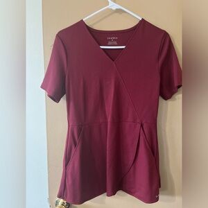 Jaanuu Spinryx burgundy scrub top. Small iron burn on front. Size S